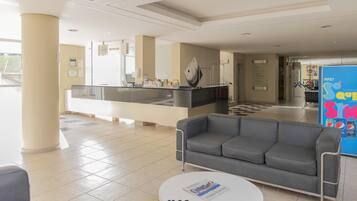 A hotel reception area with a reception desk, a sofa, and a coffee table.