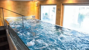 A hot tub with a glass barrier and a view of the outside.