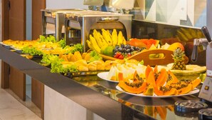 Un buffet con un'ampia scelta di frutta e verdura, tra cui banane, uva e ananas.