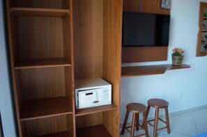 Ein Raum mit Holzböden, einem an der Wand montierten Fernseher und zwei Hocker.