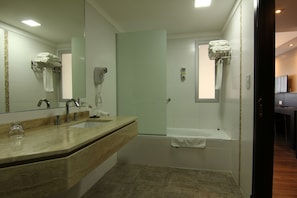 Un baño moderno con un espejo grande, un lavabo, una ducha y una bañera.