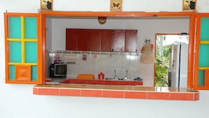 A kitchen with a red and yellow color scheme, a sink, a stove, and cabinets. - Finca Hotel Fatima (Armenia)