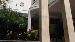 A multi-story building with a white facade, multiple windows, and balconies.