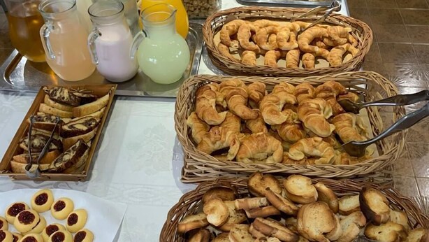A buffet table with various food items and beverages.