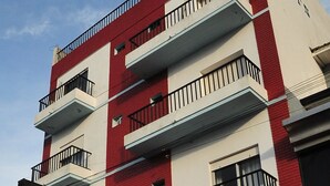 A multi-story building with balconies and a sign reading "Frasi's Hotel".