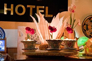A hotel reception area with a 'HOTEL' sign, decorative vases with flowers, and traditional patterned tableware. - Hotel Real Malintzi Tlaxcala (Tlaxcala)