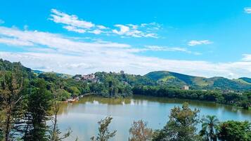 Un lago rodeado de colinas con edificios a lo lejos.