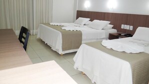 Une chambre d’hôtel avec deux lits, une table en bois et une chaise.