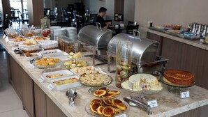 Un buffet proposant divers plats et, au fond, on aperçoit un homme.