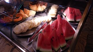Monipuolinen buffet, jossa on tarjolla erilaisia hedelmiä ja juustoja.