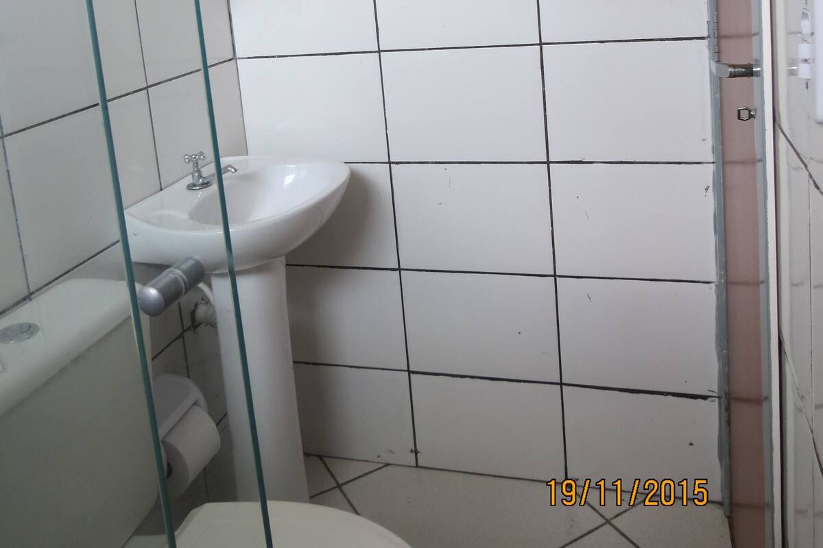 A bathroom with a white sink, toilet, and glass shower enclosure.