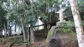 A natural setting with a rock formation, a small pond, and a statue. - Água Doce Praia Hotel (Ubatuba)
