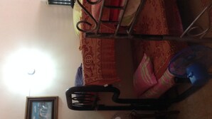 A room with a bunk bed, a chair, a fan, and a framed picture on the wall. - Voyager Int'l Hostel Panamá City (Panama City)