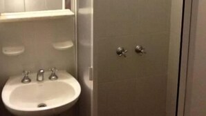 Un bagno con lavandino, specchio e doccia.