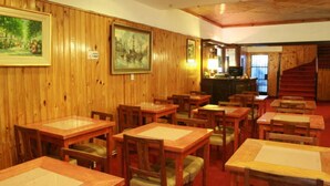 Un ristorante con pareti in legno, diversi tavoli e sedie.