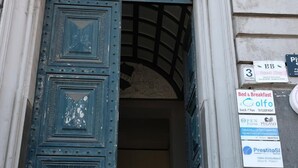 A blue door with a decorative metal grille, a stone wall with a plaque, and a sign for a bed and breakfast. - B&B Il Golfo (Naples)