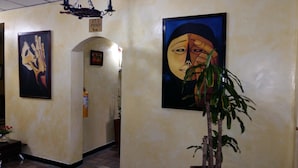 A hallway with a fire extinguisher, a sign indicating room number 2/3, and a framed artwork on the wall. - Hotel Europa (Bogota)