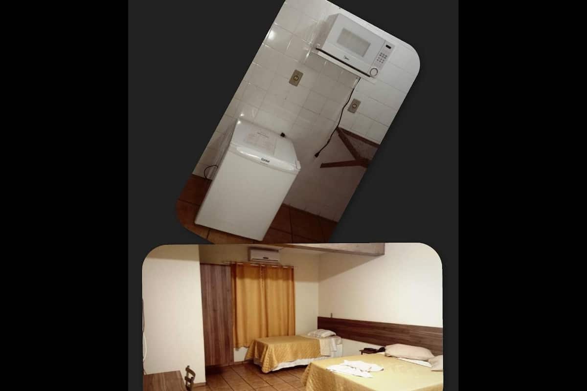 Une chambre d’hôtel comprenant un lit, une table de chevet, une commode, une fenêtre avec des rideaux et un climatiseur fixé au mur.