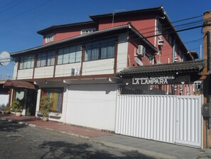 A two-story building with a red and white facade, a gated entrance, and a sign that reads "POUSADA RISTORANTE LA LAMPARA". - Pousada La Lampara (Cabo Frio)