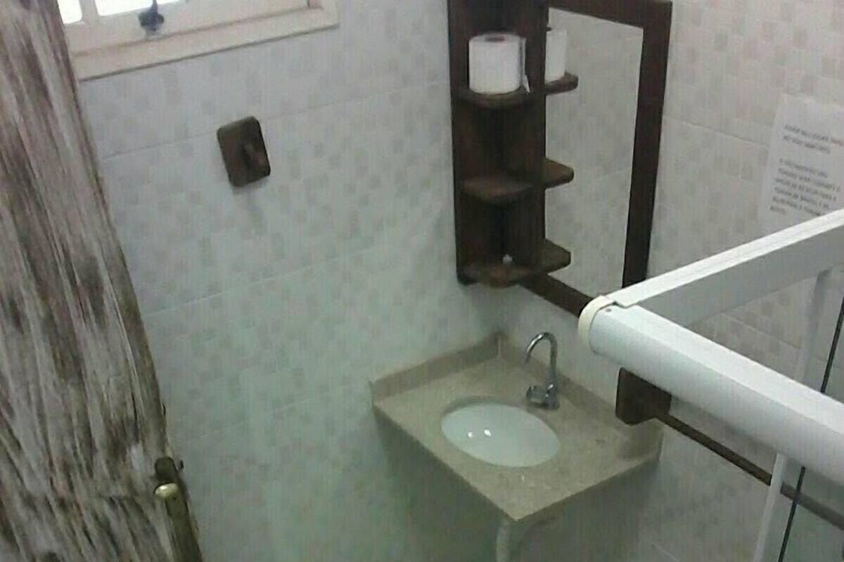 Une petite salle de bain avec un lavabo, un miroir et un sol carrelé.