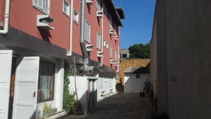 Una calle estrecha flanqueada por edificios con balcones y ventanas.