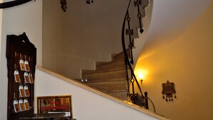 A staircase with a wooden handrail and a wall with decorative wall hangings. - Hotel Alp Guesthouse (Istanbul)