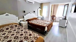 A hotel room with two beds, a desk, a chair, and a wardrobe. - Hotel Alp Guesthouse (Istanbul)