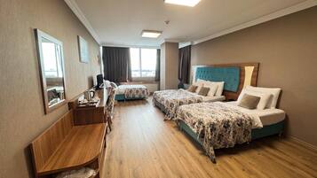 Una habitación de hotel con dos camas, un escritorio, una silla y un pequeño estante.