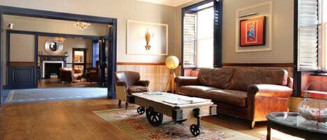 A spacious living room with a large sofa, a coffee table, and a fireplace.