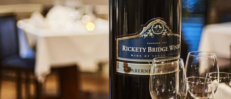 A bottle of Rickety Bridge Wine on a table with several wine glasses.