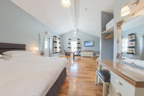 Una habitación de hotel moderna con una cama grande, un escritorio y un espejo.