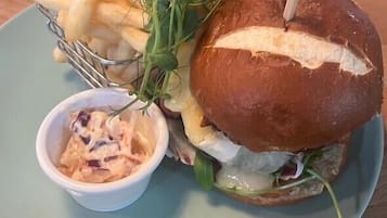 Un entrepà amb pa, lletuga i una porció de patates fregides damunt d'un plat.