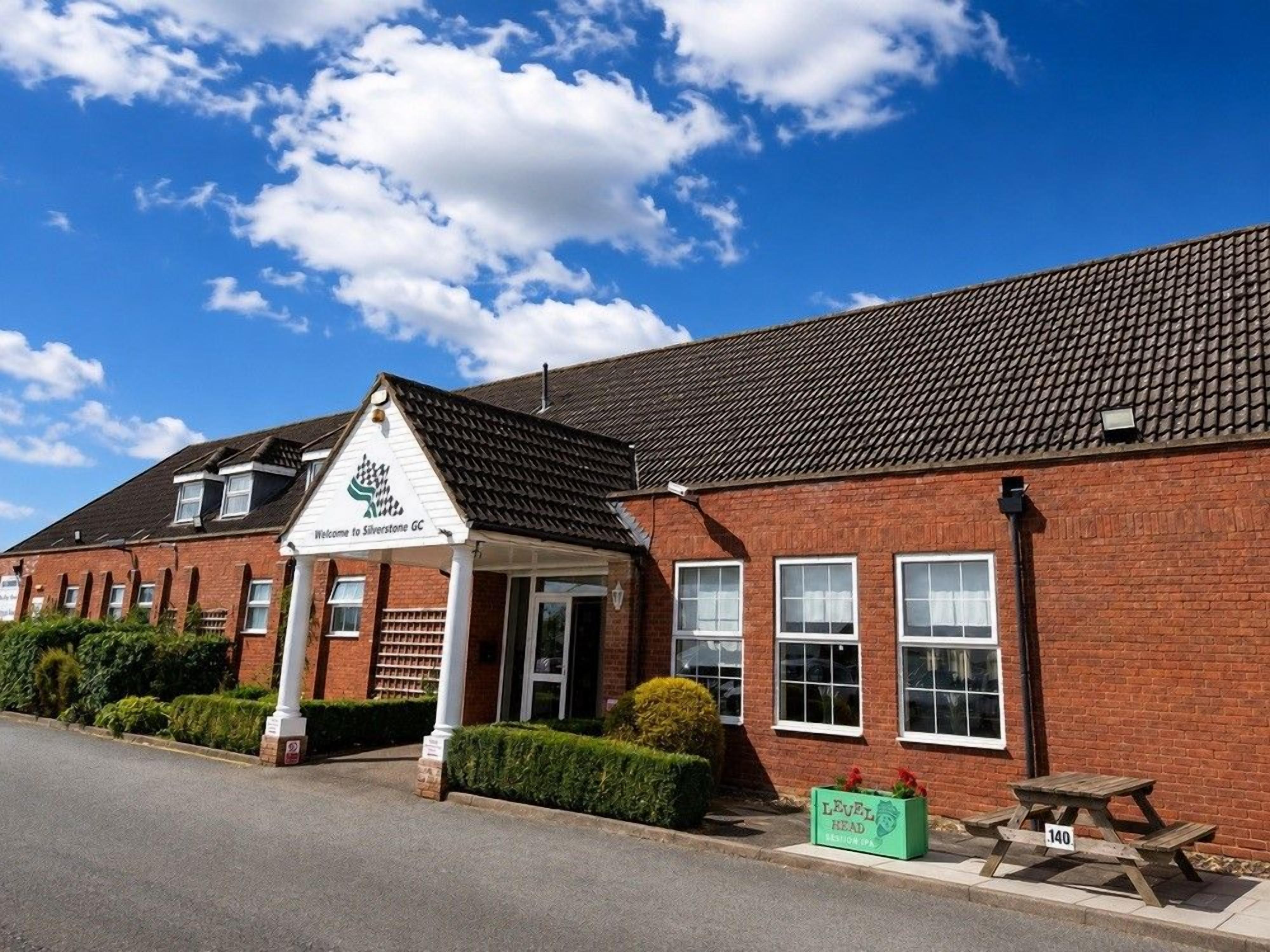 Un edificio de ladrillo con un letrero que dice 'Welcome to Silverstone GC'.