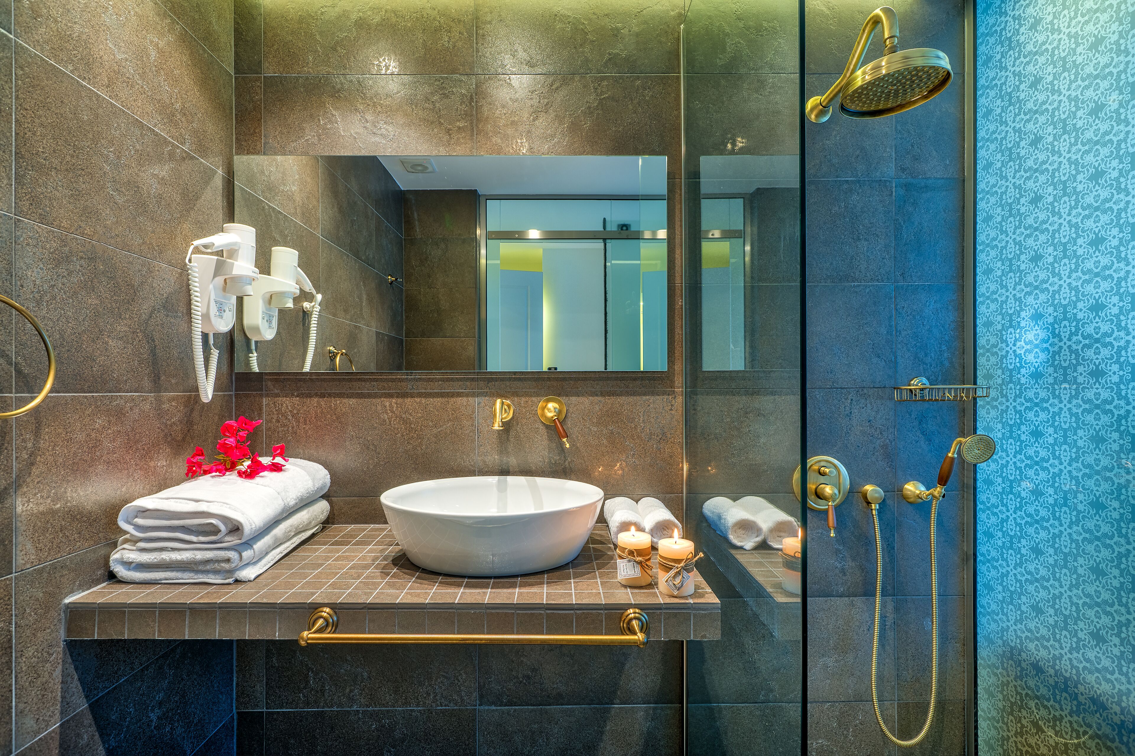 Une salle de bain moderne avec un grand lavabo, un miroir, une douche et un porte-serviettes.