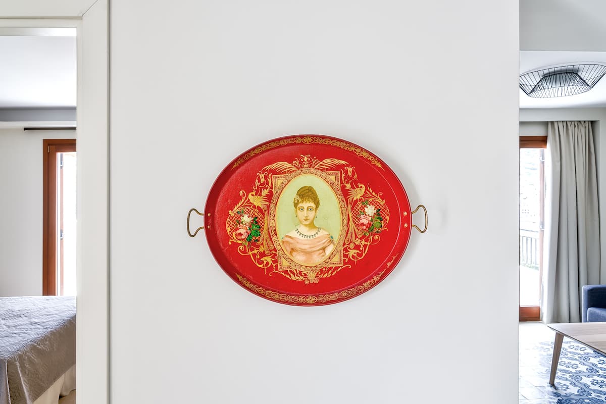 A wall-mounted decorative plate with a portrait and floral design.