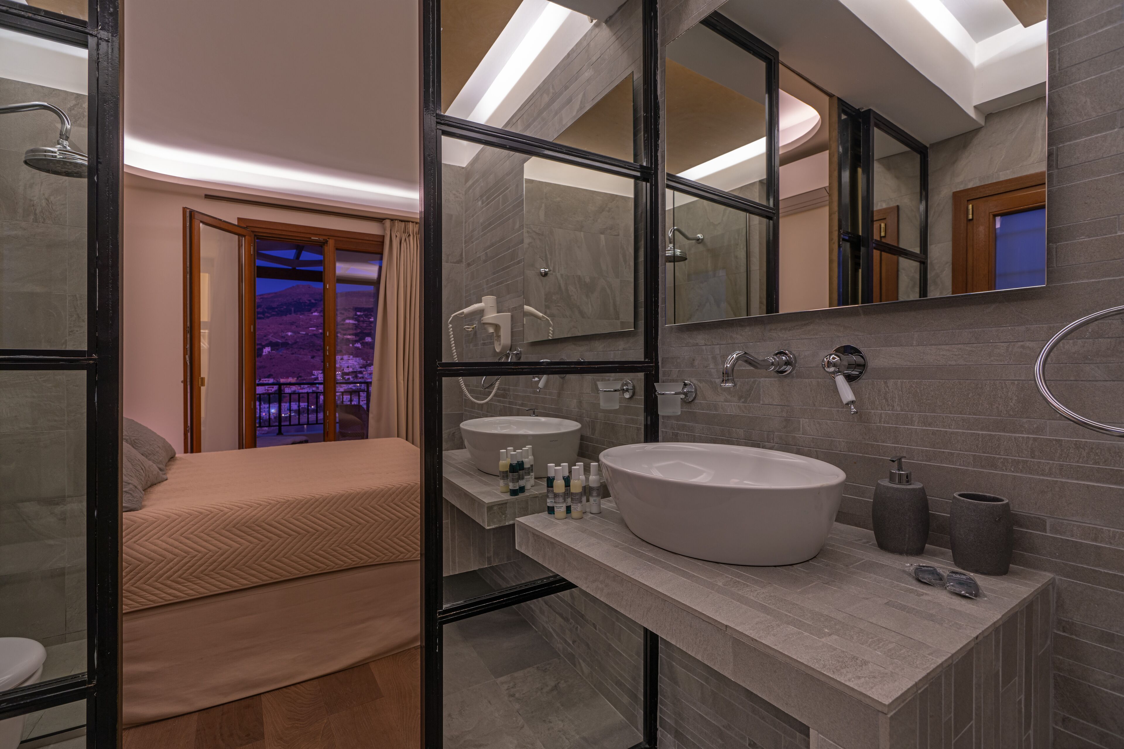 Un baño moderno con un espejo grande, una bañera y un lavabo.