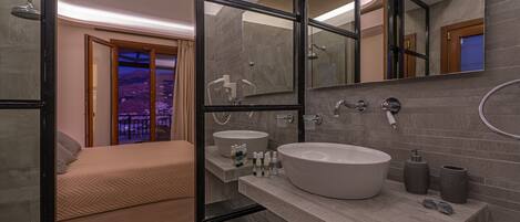 Un baño moderno con un espejo grande, una bañera y un lavabo.