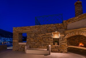Un edificio de piedra con chimenea y una estructura metálica en el techo.