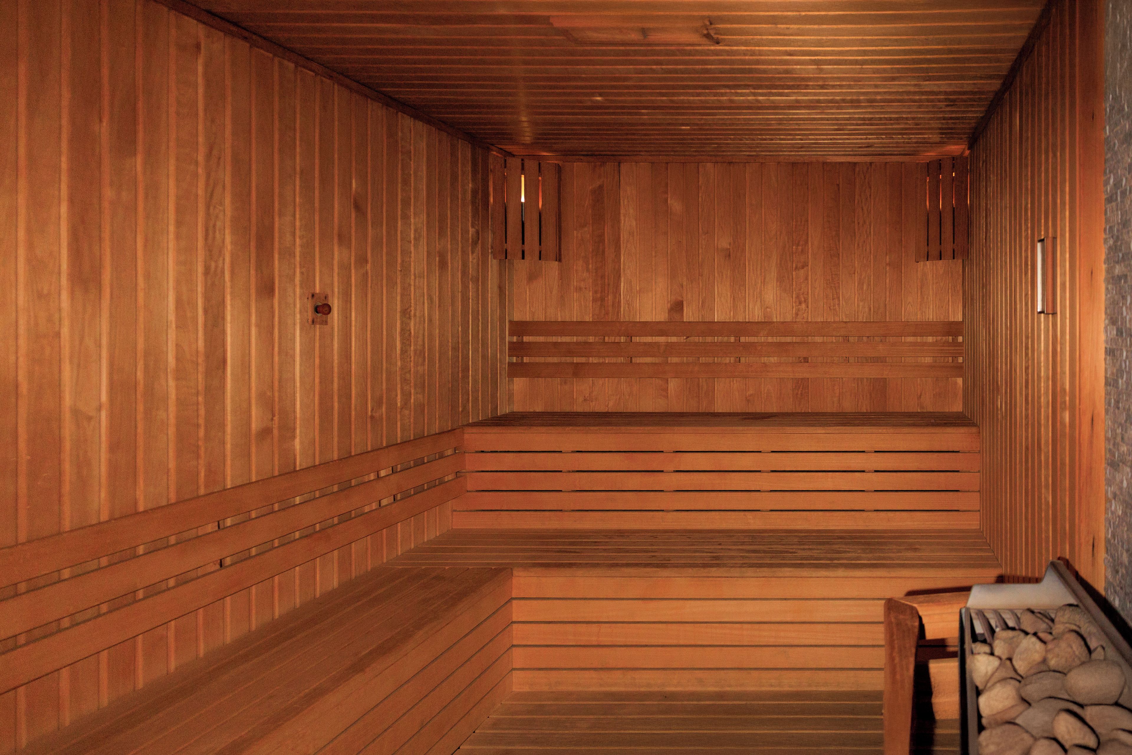 A sauna room with wooden walls and benches.