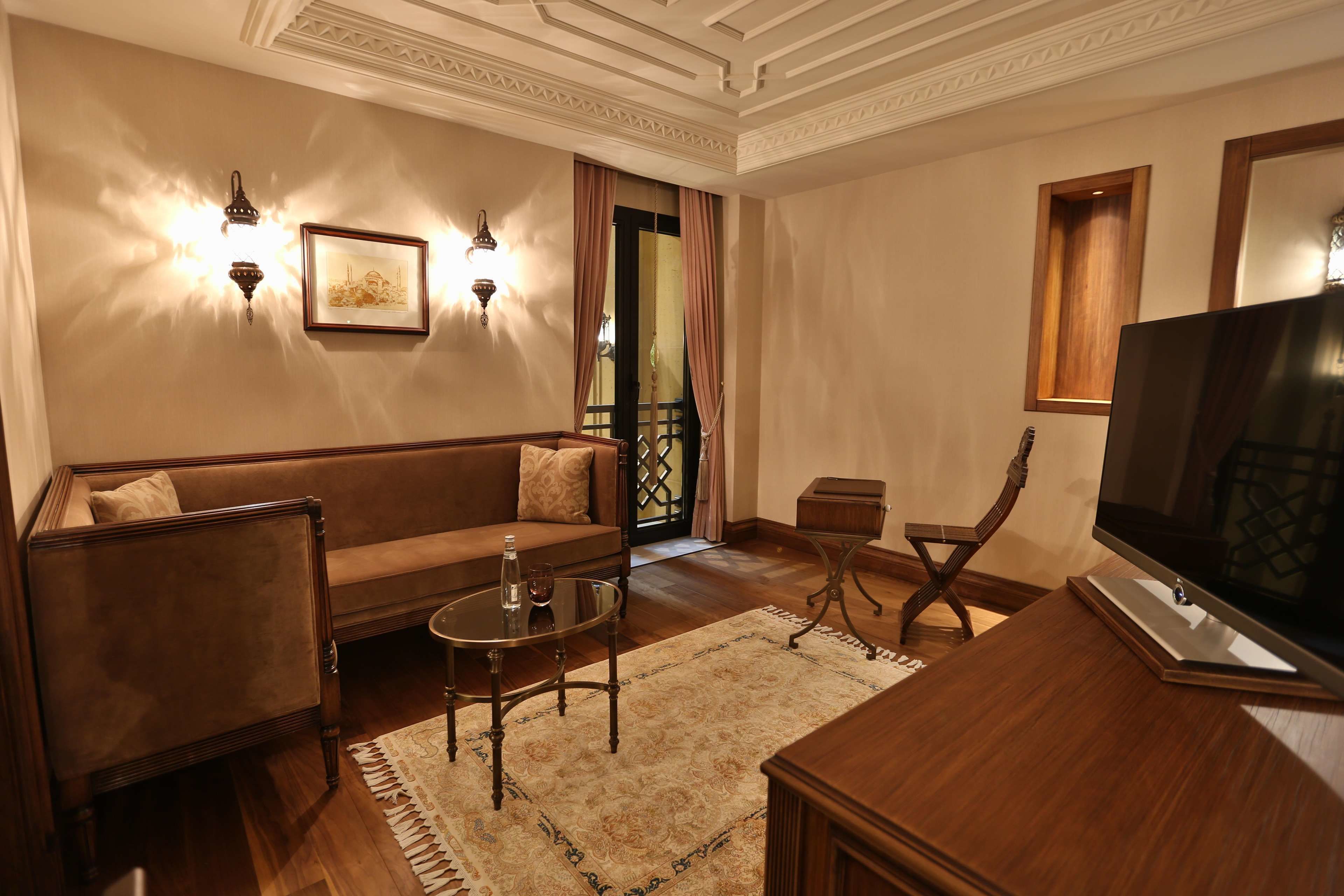 Una sala de estar con un sofá, una mesa de centro, un televisor y una mesita de madera.