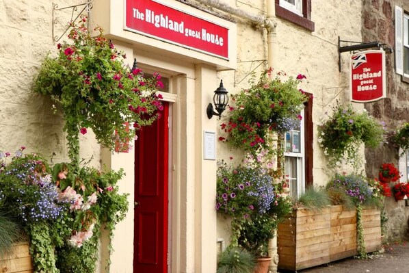A building with a red door and a sign reading 'The Highland Guest House'. - The Highland Guest House (Callander)