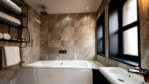 A modern bathroom with a large bathtub, a sink, and a shower. - Charter House (Newport)