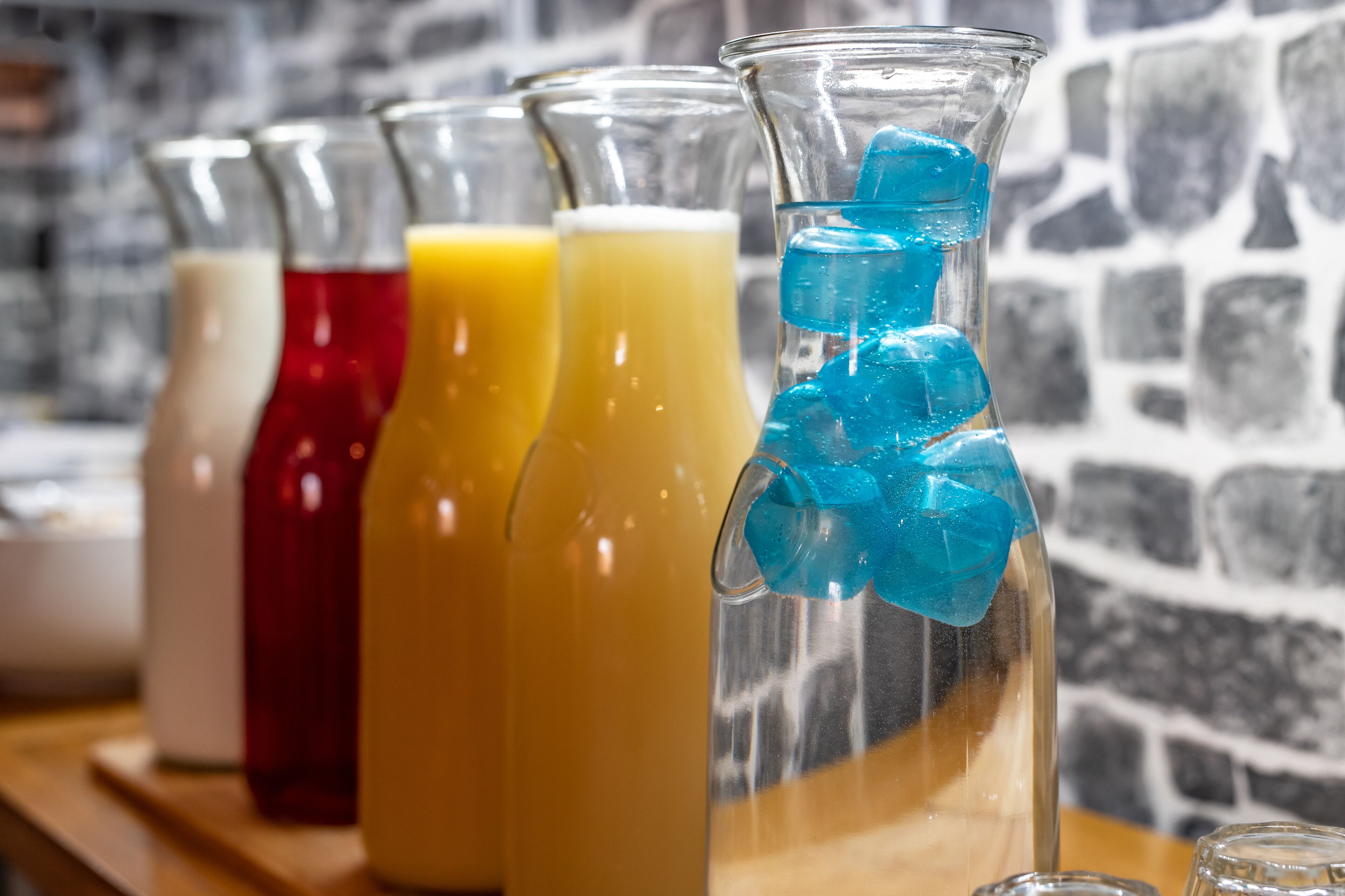 A row of glass bottles with different colored liquids, each with a unique shape and design.