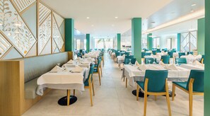 A spacious restaurant with multiple tables and chairs, a modern interior design, and a view of the outdoors.