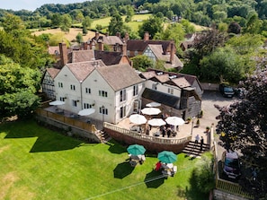 A large, traditional building with multiple windows and a covered patio area with outdoor seating. - The Manor at Abberley (Worcester)