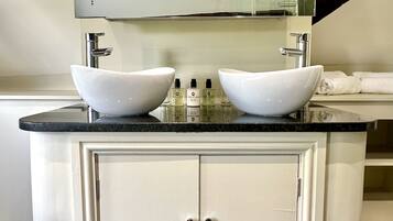 Une salle de bain avec un meuble-lavabo à deux vasques, un miroir au-dessus du lavabo et un meuble de rangement en dessous.