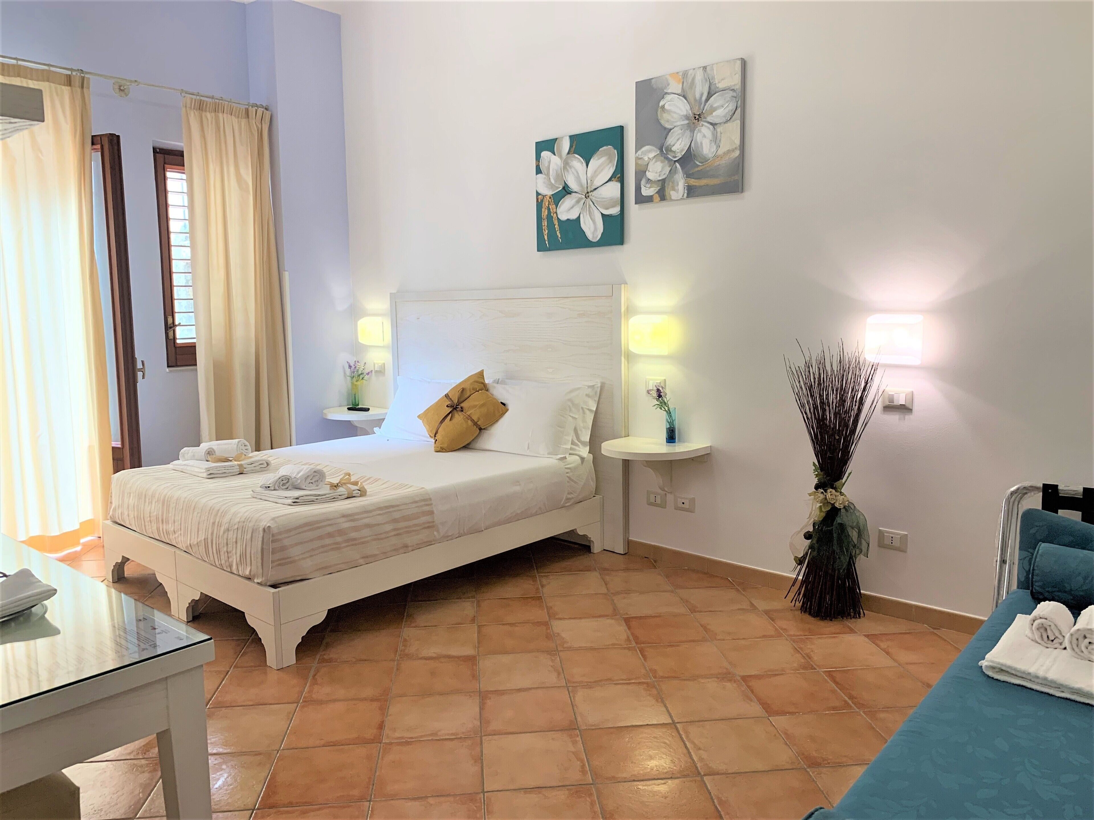 A neatly arranged bedroom with a bed, bedside tables, and a nightstand.