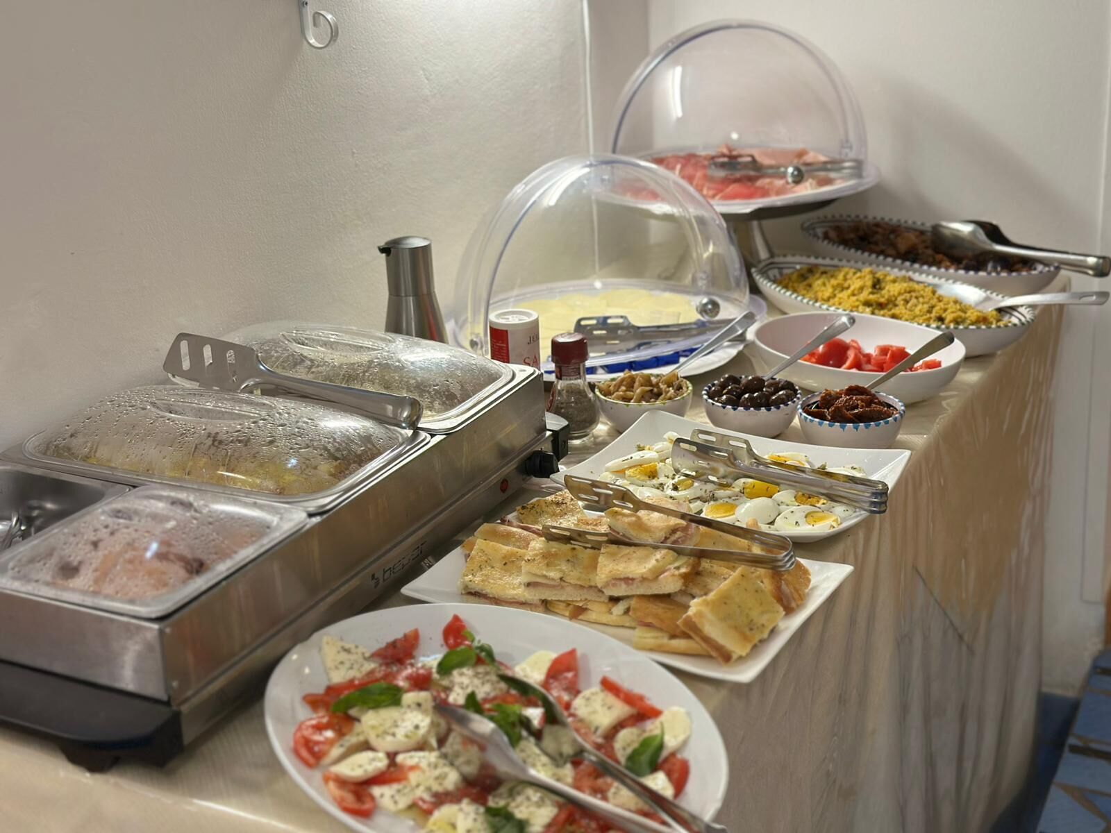 A buffet with various food items, including pasta, eggs, and salads.