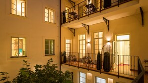 A multi-level building with balconies, large windows, and indoor plants. - Old Royal Post Boutique Hotel & Premium Suites (Prague)