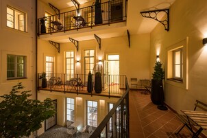 Um interior em vários níveis, com varanda, áreas de estar e escadaria.
